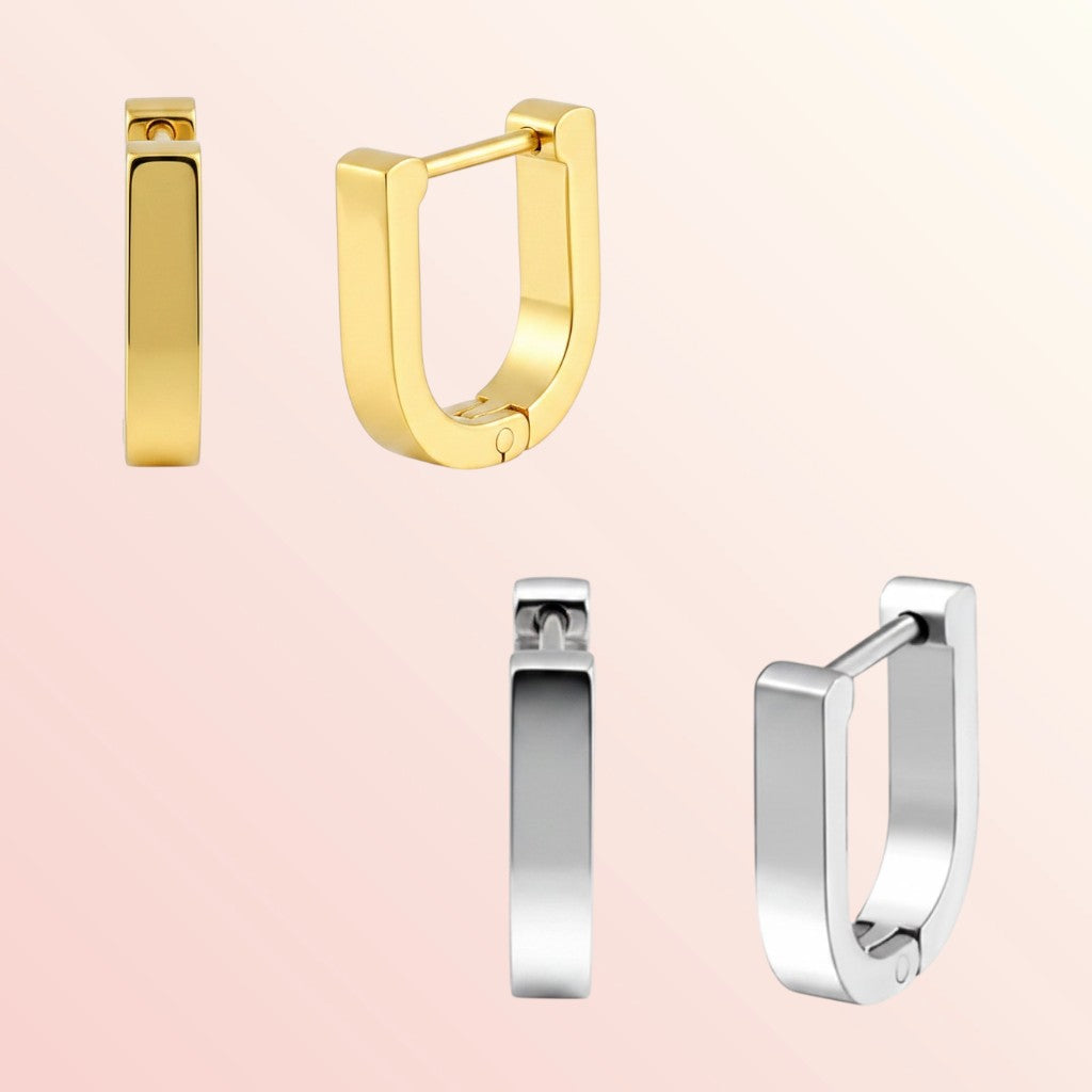 Gold and silver hoop earrings on a light pink background