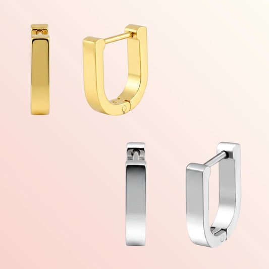 Gold and silver hoop earrings on a light pink background