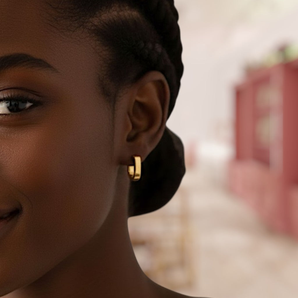 Close-up of a person wearing a gold hoop earring with a blurred background