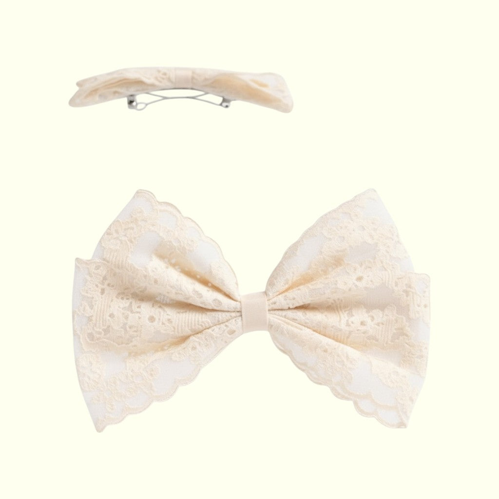 Cream-colored bow hair clip on a white background
