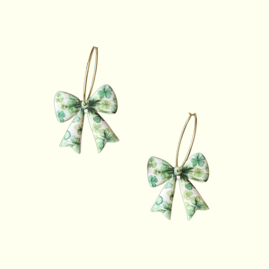 Pair of green bow-shaped earrings on a white background