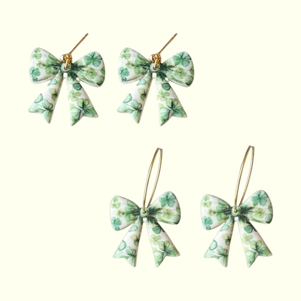 Set of four green bow-shaped earrings on a white background