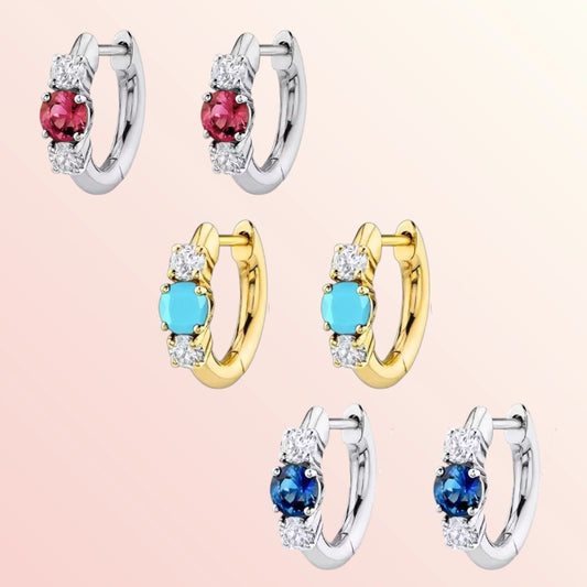 Set of hoop earrings with gemstones on a light pink background