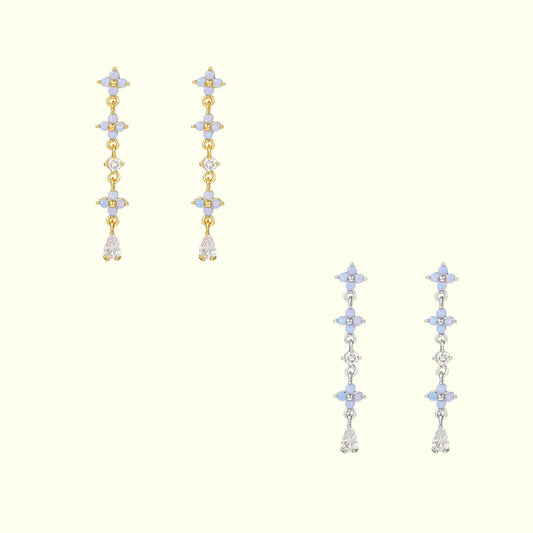 Pair of gold and silver earrings with star-shaped elements on a white background