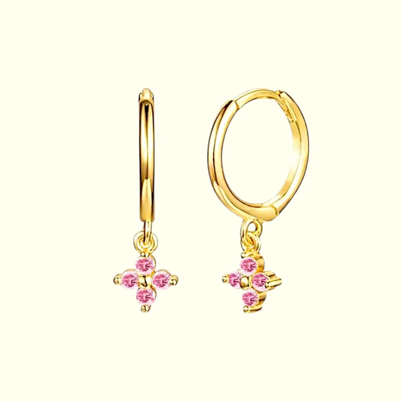 Gold hoop earrings with pink gemstones on a white background