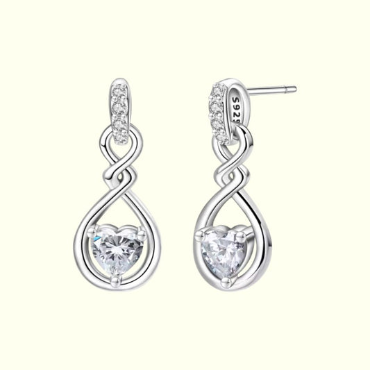 Silver earrings with heart-shaped gemstones on a white background